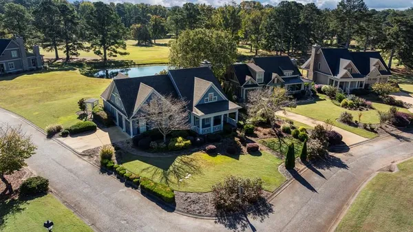 an aerial view of a house with swimming pool and outdoor seating
