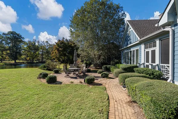 a view of a house with backyard and sitting area