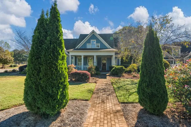 a view of a house with backyard and sitting area
