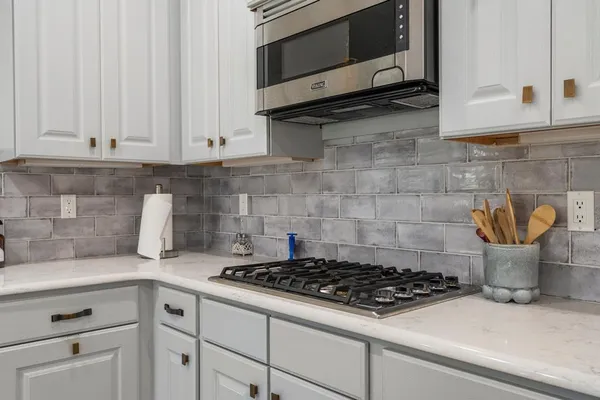 a kitchen with white cabinets and stainless steel appliances