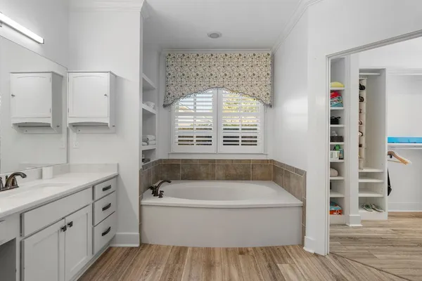a bathroom with a double vanity sink a mirror and a bathtub