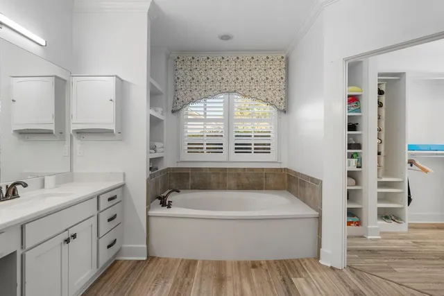 a bathroom with a double vanity sink a mirror and a bathtub