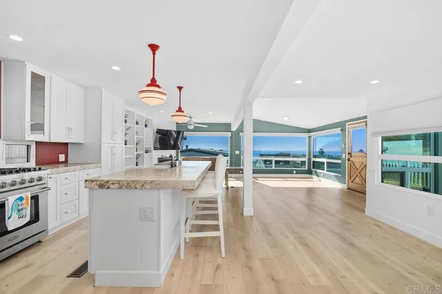 a view of a big room with wooden floor and windows