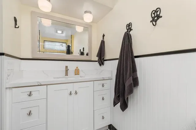a bathroom with a sink vanity and a mirror