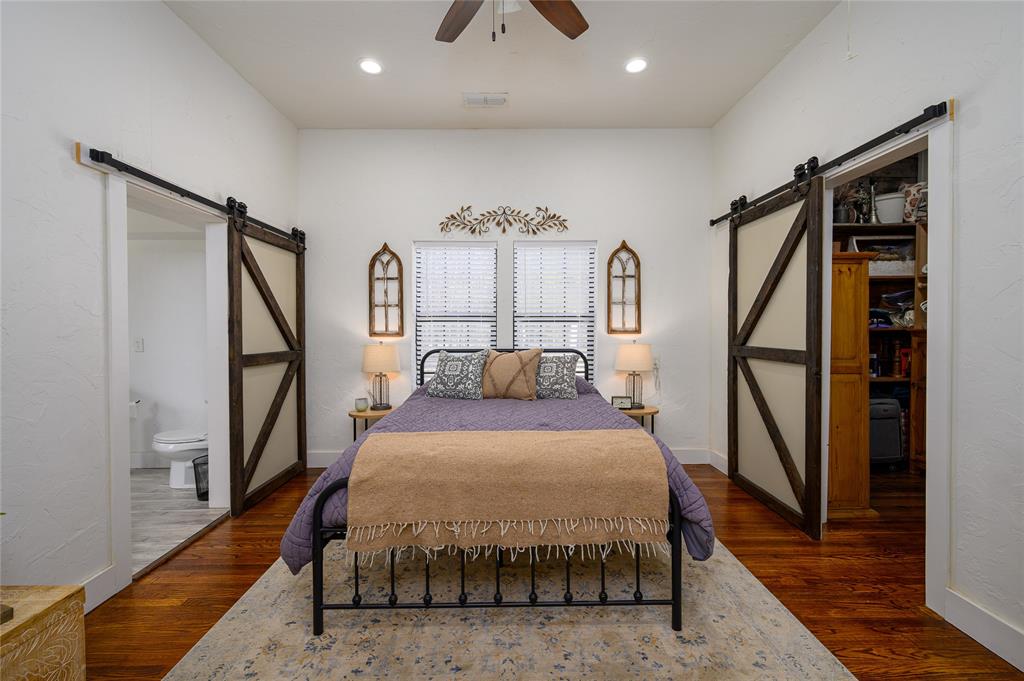 4597 West Line Road Whitesboro, TX 76273 - Photo 19 of 31 a bed room with a bed and a chandelier