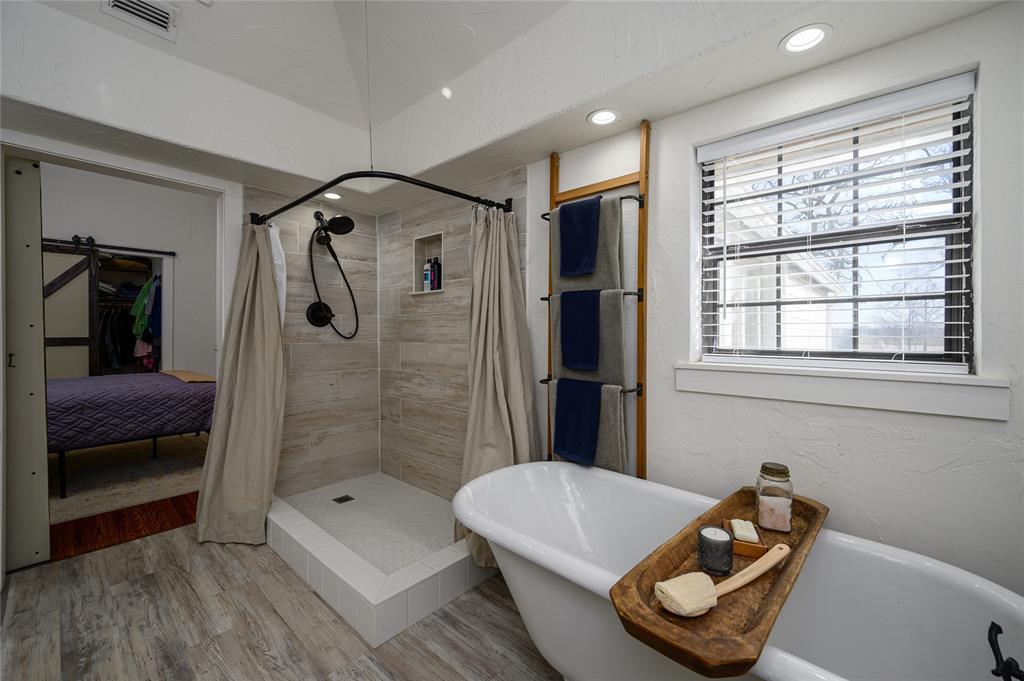 4597 West Line Road Whitesboro, TX 76273 - Photo 22 of 31 a bathroom with a tub and a shower