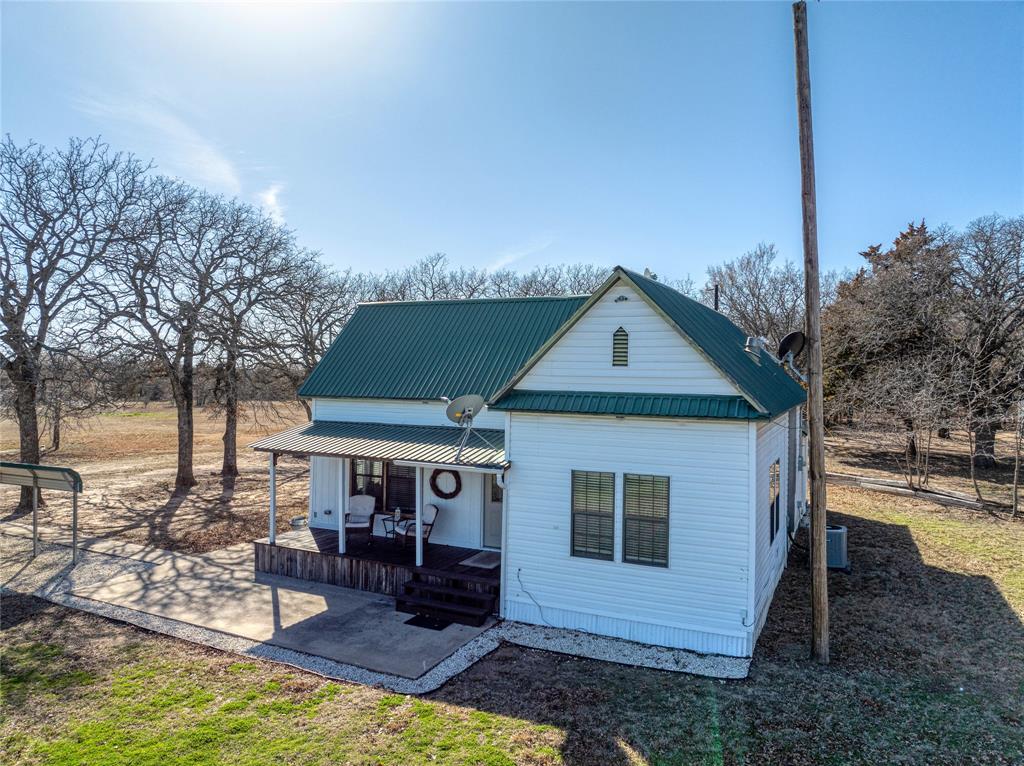 4597 West Line Road Whitesboro, TX 76273 - Photo 6 of 31 a front view of house with yard and trees in the background