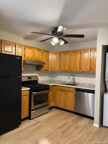 a kitchen with stainless steel appliances granite countertop hardwood floor sink stove and refrigerator