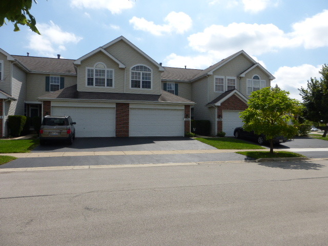 5614 Elizabeth Place, Unit 102 Rolling Meadows, IL 60008 - Photo 1 of 22 a front view of a house with a yard and garage