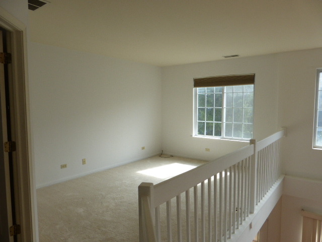 5614 Elizabeth Place, Unit 102 Rolling Meadows, IL 60008 - Photo 9 of 22 a view of a bedroom with wooden floor and a window
