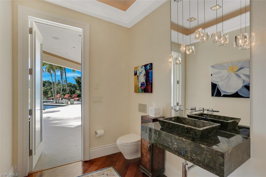 2343 Alexander Palm Naples, FL 34105 - Photo 27 of 35 a bathroom with a granite countertop sink a toilet a mirror and shower curtain