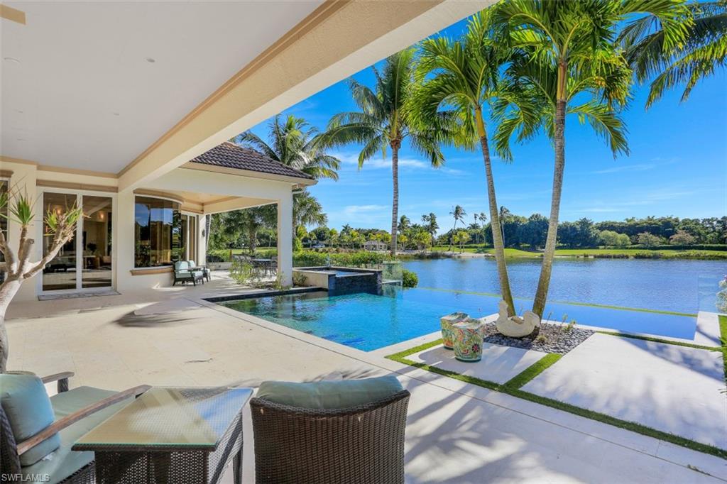 2343 Alexander Palm Naples, FL 34105 - Photo 31 of 35 a view of a lake with couches chairs under an umbrella