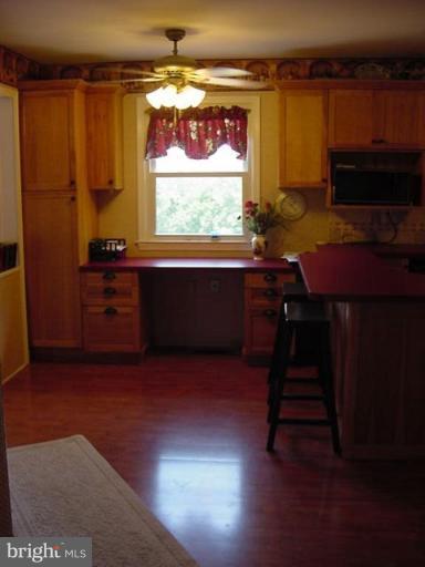 6353 Old Bust Head Road Warrenton, VA 20187 - Photo 12 of 13 a kitchen with stainless steel appliances wooden cabinets and a stove top oven