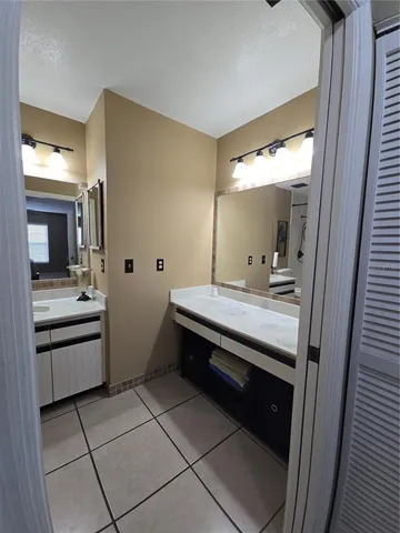 a spacious bathroom with a granite countertop sink and a mirror