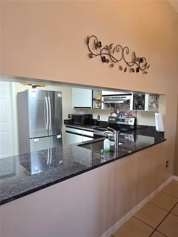 a kitchen with stainless steel appliances granite countertop a sink a stove and refrigerator