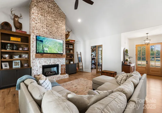 a living room with furniture a fireplace and a flat screen tv