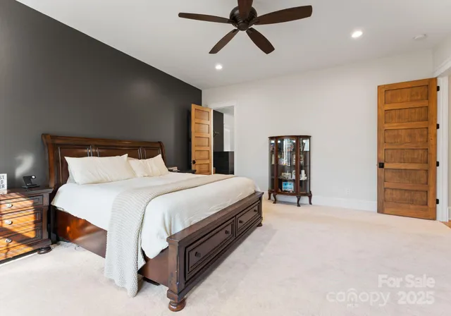 a spacious bedroom with a bed and a ceiling fan