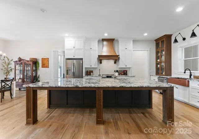 a kitchen with stainless steel appliances granite countertop a sink and a stove