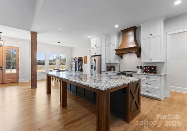 a kitchen with stainless steel appliances granite countertop a stove and a wooden floors
