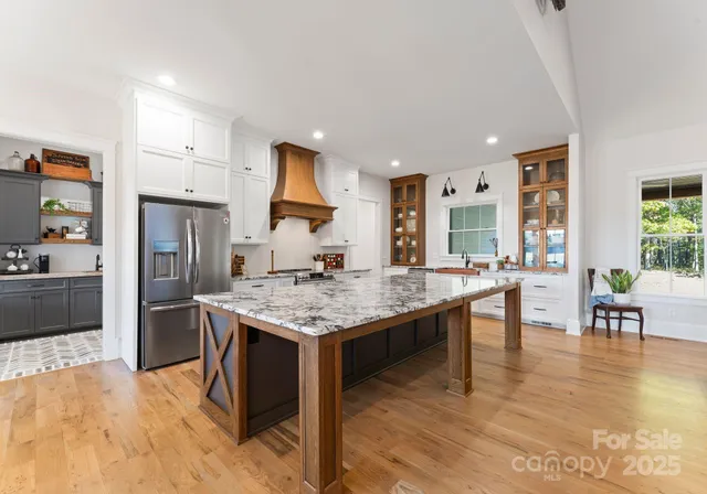 a kitchen with stainless steel appliances granite countertop a kitchen island a stove and a sink