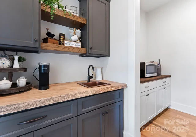 a kitchen with granite countertop stainless steel appliances a sink a stove and cabinets