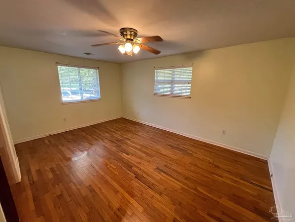 a view of an empty room with a chandelier fan