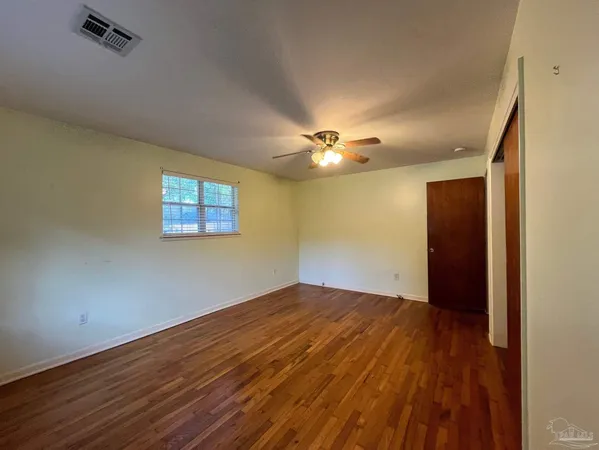 a view of empty room with wooden floor