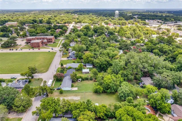 an aerial view of residential houses with outdoor space and swimming pool