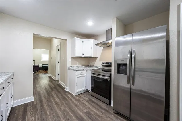 a kitchen with a refrigerator and a stove top oven