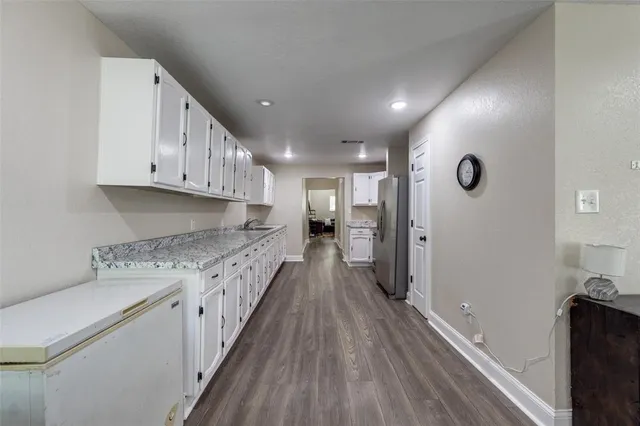 a kitchen with cabinets and wooden floor