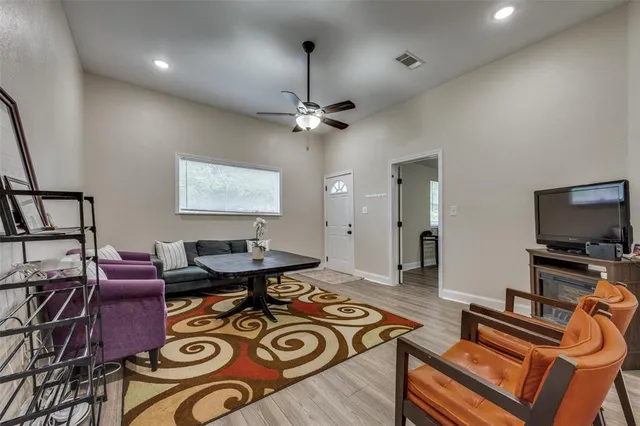 a living room with furniture a flat screen tv and kitchen view