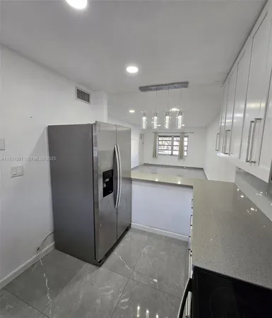a kitchen with a refrigerator and a sink