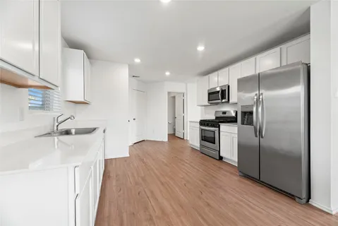 a kitchen with granite countertop a refrigerator and a sink