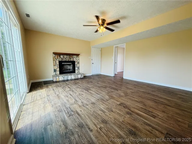 a view of an empty room with a window and a fireplace