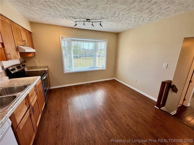 a view of a kitchen with a sink wooden floor and a window