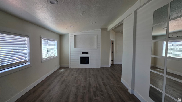 1450 North Dixie Downs Road, Unit 51 St. George, UT 84770 - Photo 8 of 25 Living area featuring wood-finish flooring and a contemporary fireplace with a shiplap surround