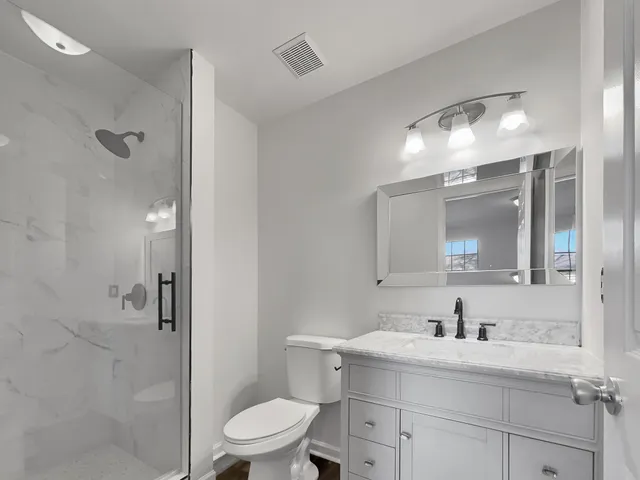 a bathroom with a sink toilet a mirror and shower