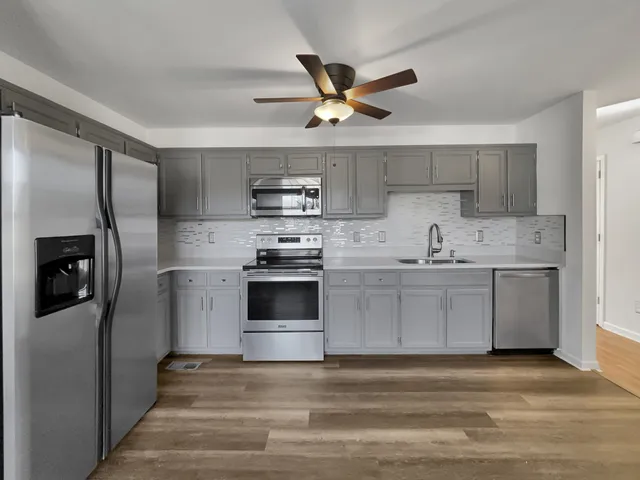 a kitchen with stainless steel appliances a stove a sink and a refrigerator