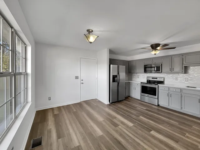 a kitchen with granite countertop a refrigerator and a stove top oven