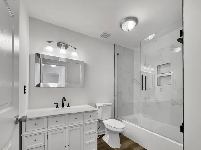 a bathroom with a sink a toilet and shower