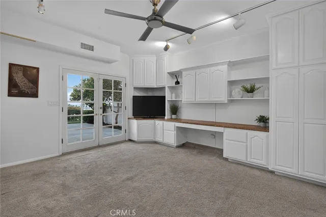 a view of a kitchen with furniture a ceiling fan and window