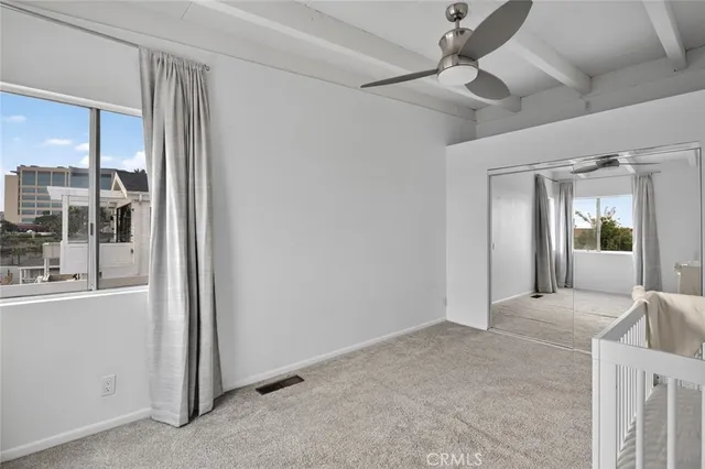 a view of a bedroom with closet and windows