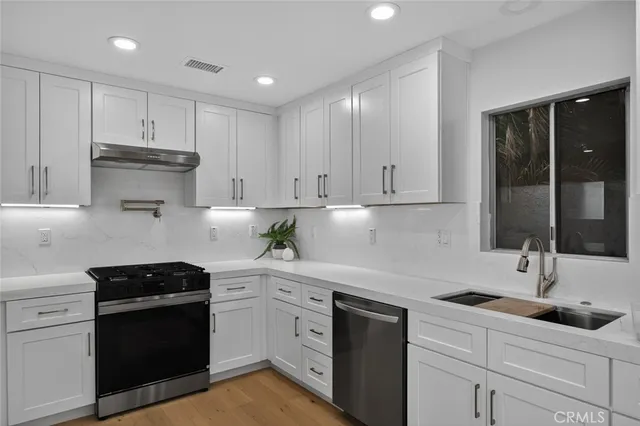 a kitchen with white cabinets and appliances