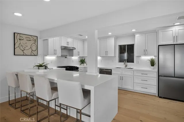 a kitchen with white cabinets and stainless steel appliances