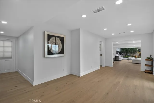 a view of a hallway with wooden floor and windows
