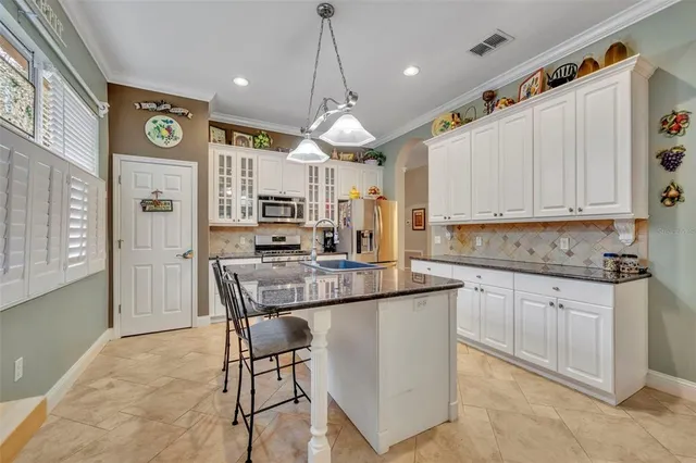 a kitchen with stainless steel appliances granite countertop a stove a sink and a refrigerator