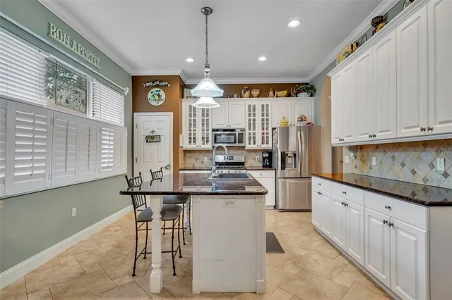 a kitchen with stainless steel appliances kitchen island granite countertop a sink and cabinets
