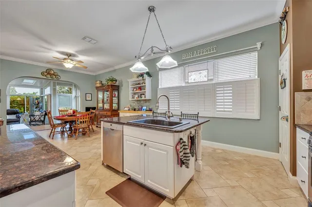a kitchen with granite countertop a stove a sink a dining table and chairs