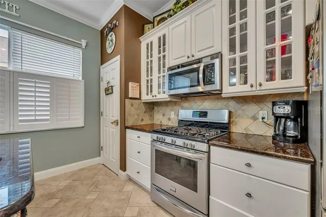 a kitchen with stainless steel appliances granite countertop a stove and a microwave