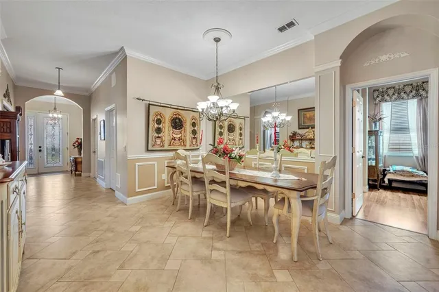 a dining room with furniture a chandelier and kitchen view